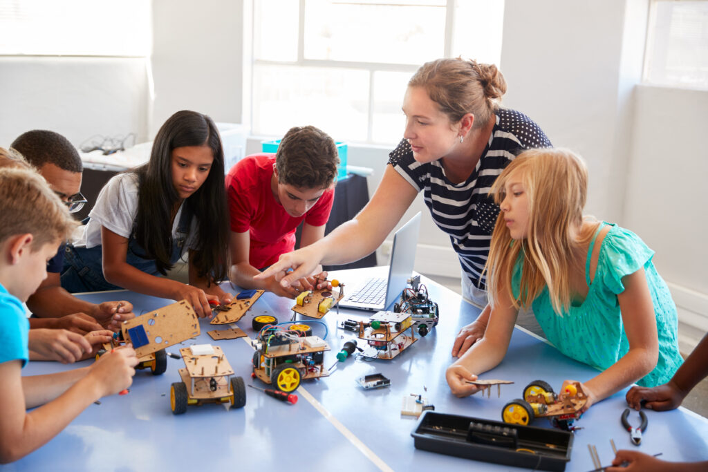 Prezent na Dzień Dziecka dla 9 latka: Students In After School Computer Coding Class Building And Learning To Program Robot Vehicle